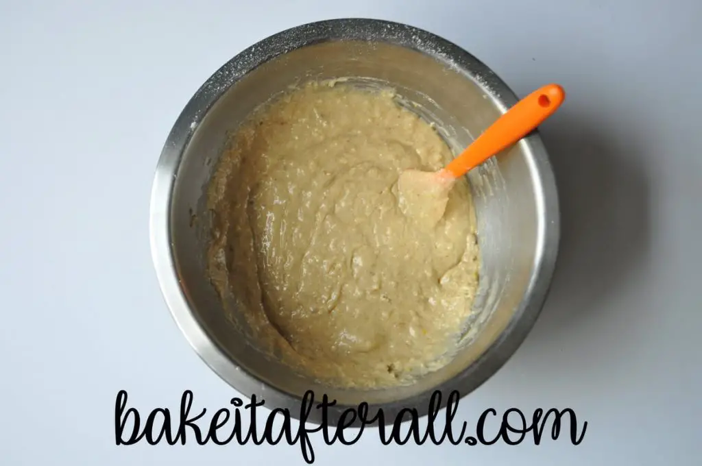 muffin batter mixed up in a bowl with a small silicone spatula