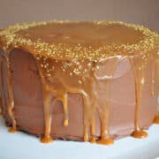 salted caramel chocolate fudge cake on a white cake plate