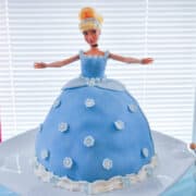 a Cinderella cake on a white cake stand