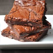 three outrageous brownies stacked on top of each other on a white plate