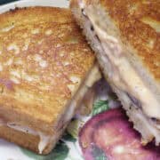 turkey pastrami Reuben sandwich cut in half and stacked on a plate