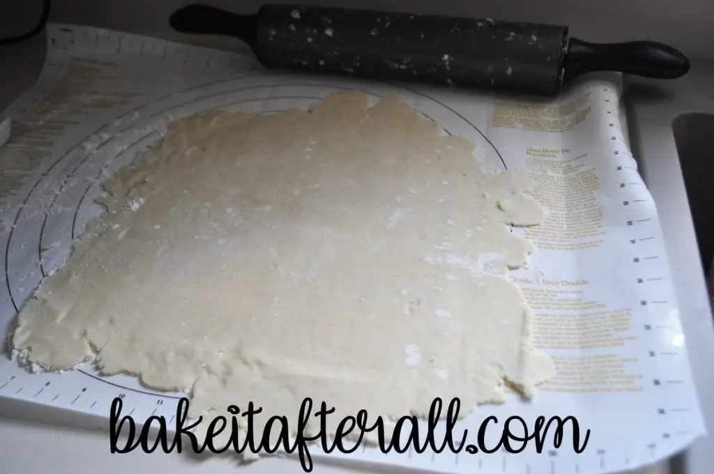 gluten free pie dough rolled out thin on a pastry mat