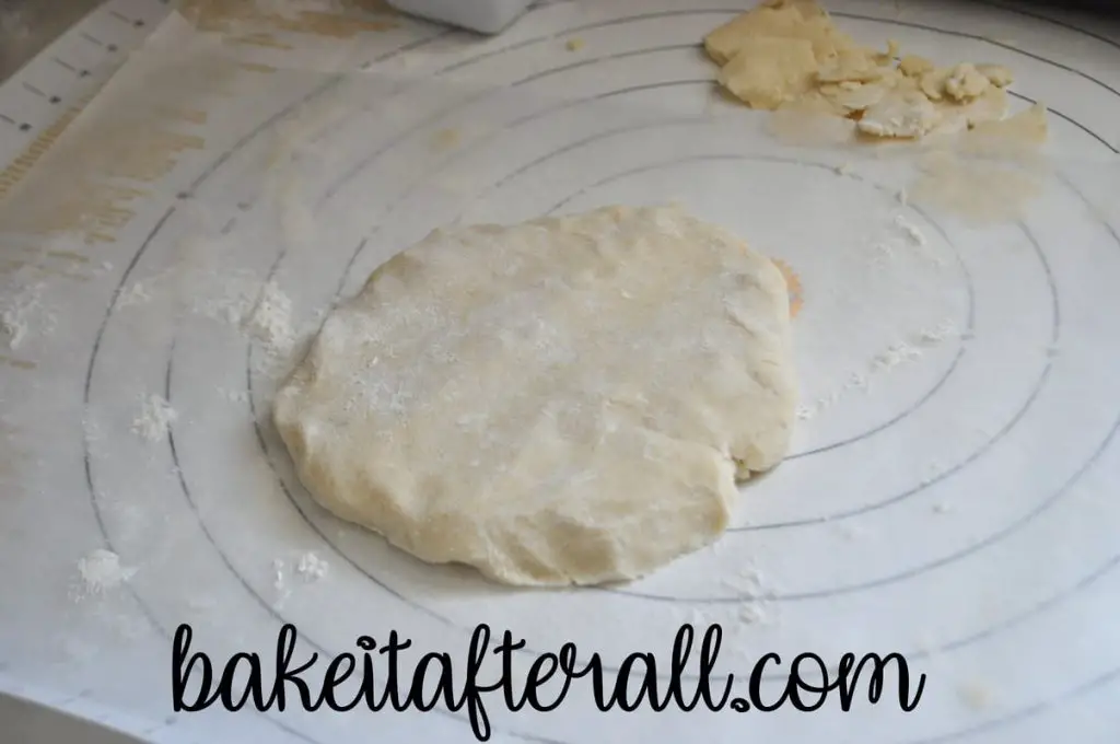 gluten free pie dough in a disc on a pastry mat
