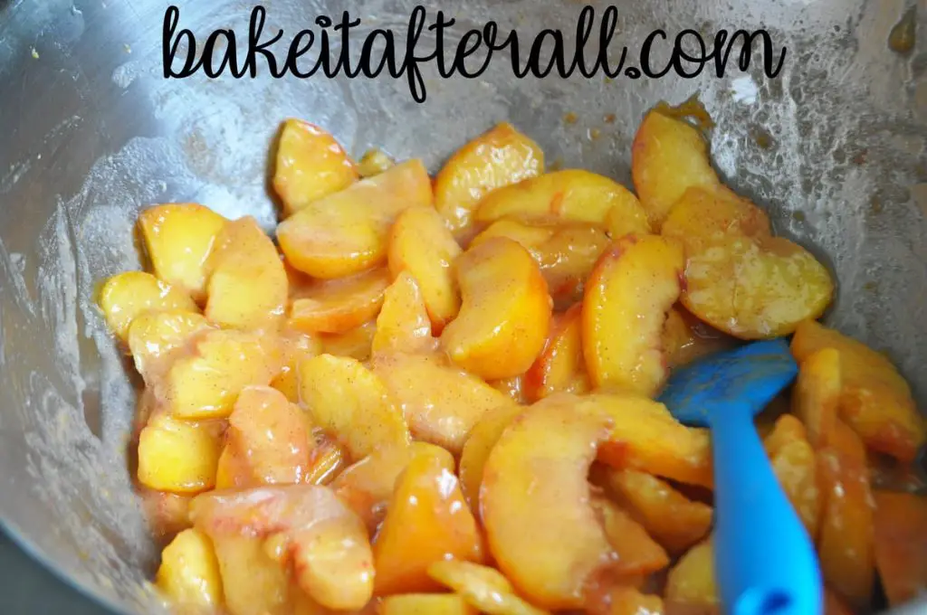 peaches in a large bowl mixed with lemon juice, cinnamon, and flour