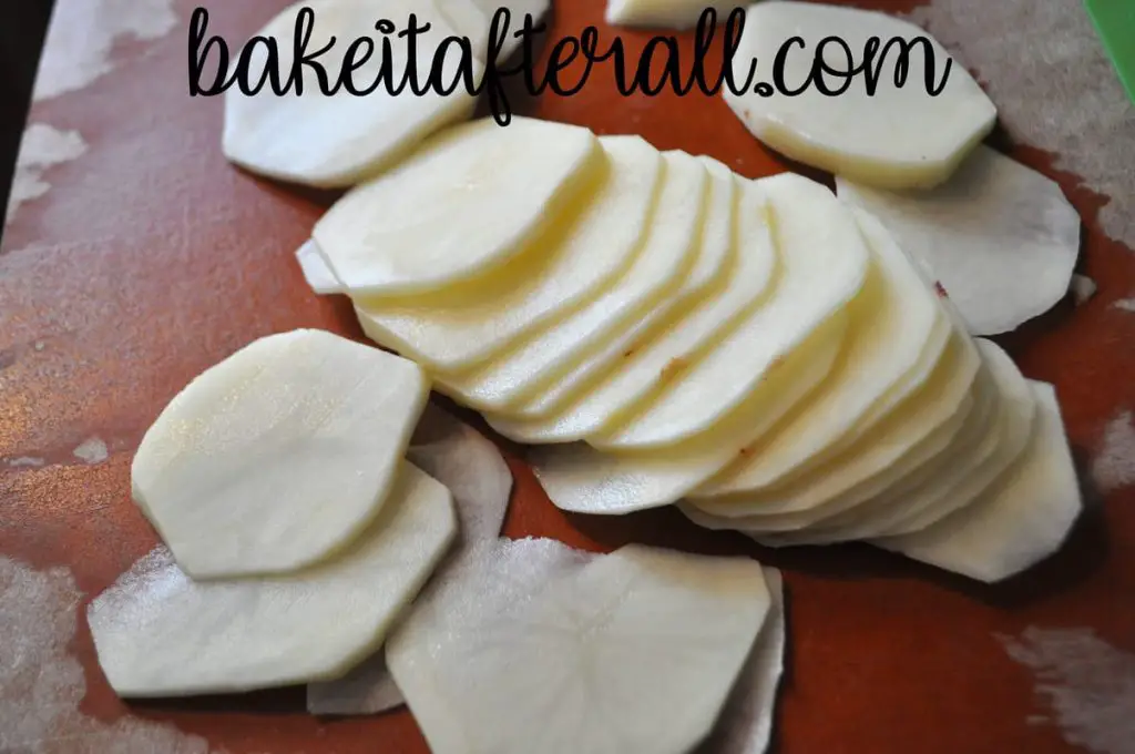 thinly sliced potatoes on a cutting board