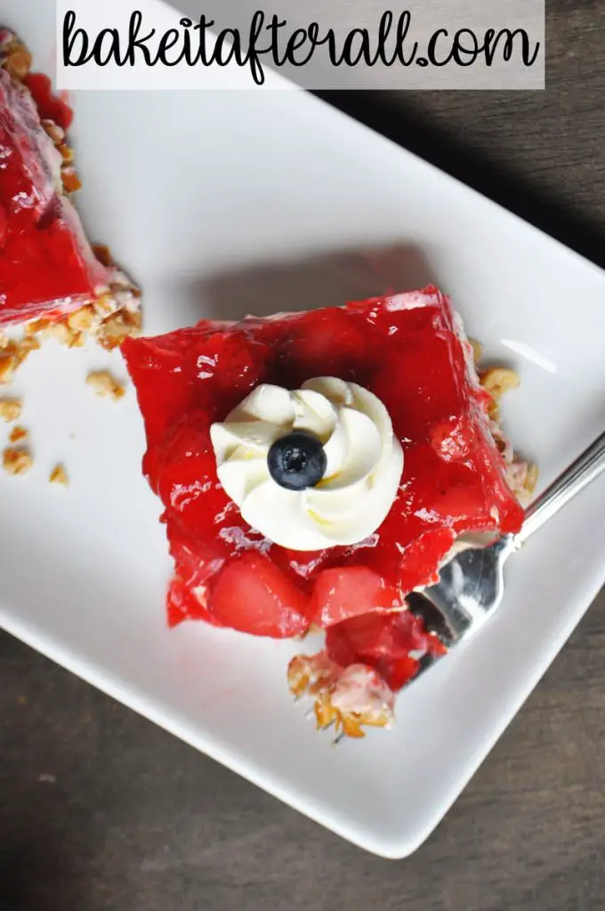strawberry pretzel jello salad with whipped cream and blueberry on top