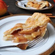 a slice of apple pie on a plate with a fork