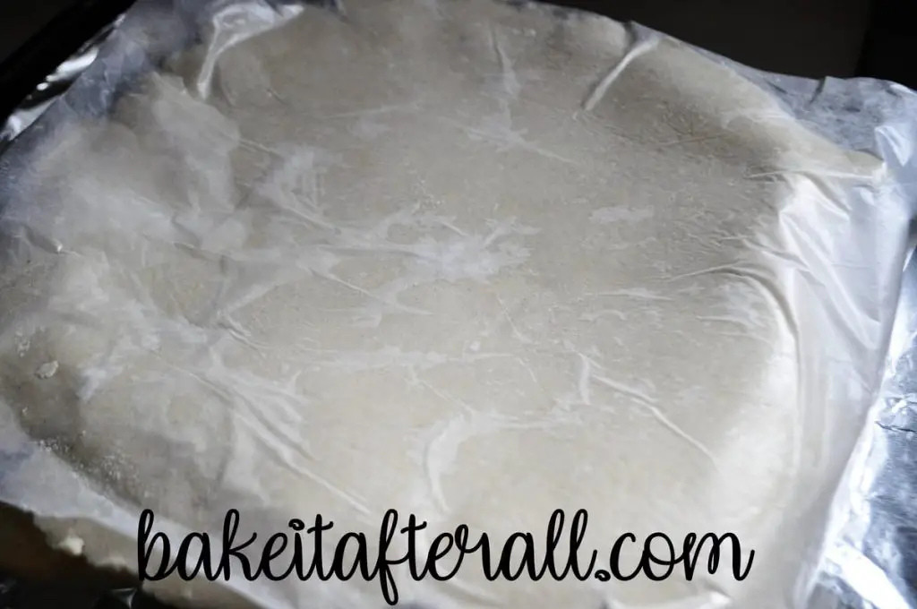 top crust laid on pie with wax paper