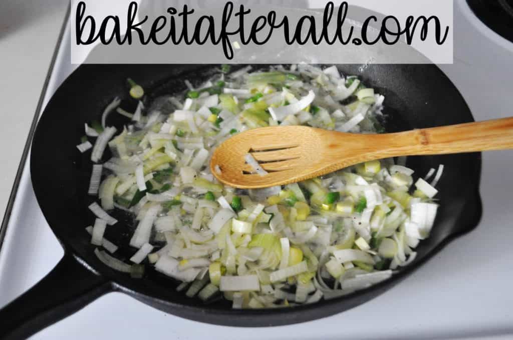 leeks and jalapenos sauteeing in butter in a cast iron skillet