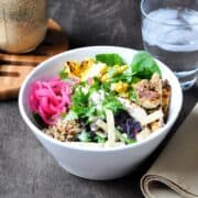 Panera Southwest Chile Lime Ranch Salad in a white bowl with a glass of water and jar of dressing