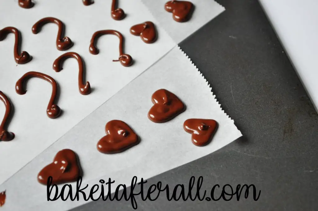 chocolate decorations piped on parchment paper