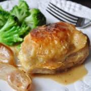 Roasted Chicken with Garlic Pan Sauce with broccoli on a white plate with a fork