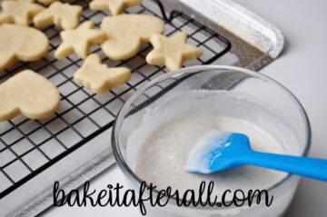 vanilla icing in a bowl next to cookies on a cooling rack