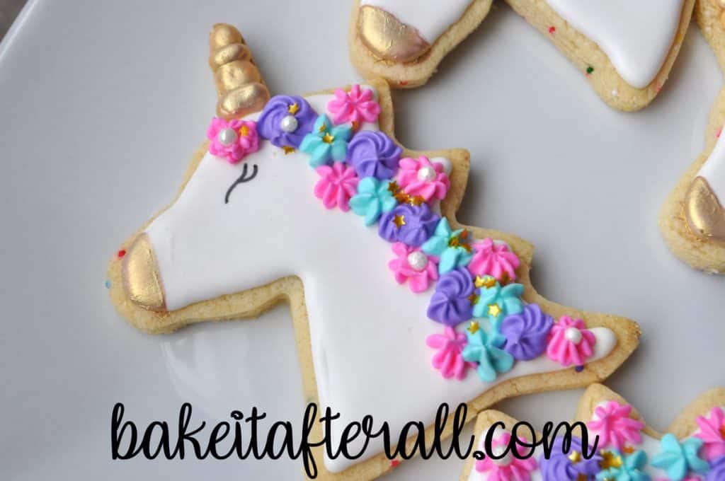 Gold luster dust painted on horn and nose of unicorn cookies