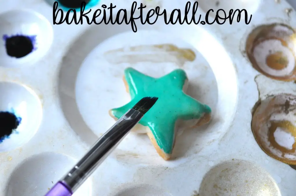 starfish cookie on a paint palette with a paintbrush held up