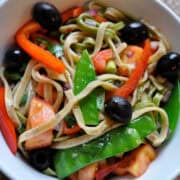 a white bowl full of healthy pasta primavera salad