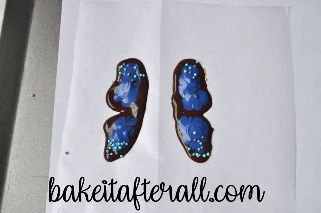 two butterfly wings outlined with chocolate and filled with melted blue candy melts