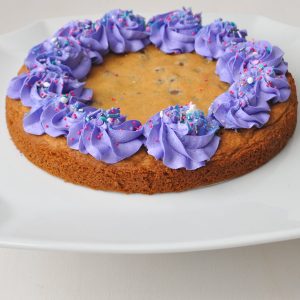 Chocolate Chip Cookie Cake with purple buttercream border and sprinkles