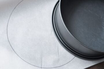 parchment paper with circle drawn in pencil and a pan on top