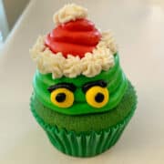 a Grinch Cupcake on a white counter