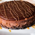 gluten free mocha cheesecake topped with chocolate ganache and drizzled with caramel sauce
