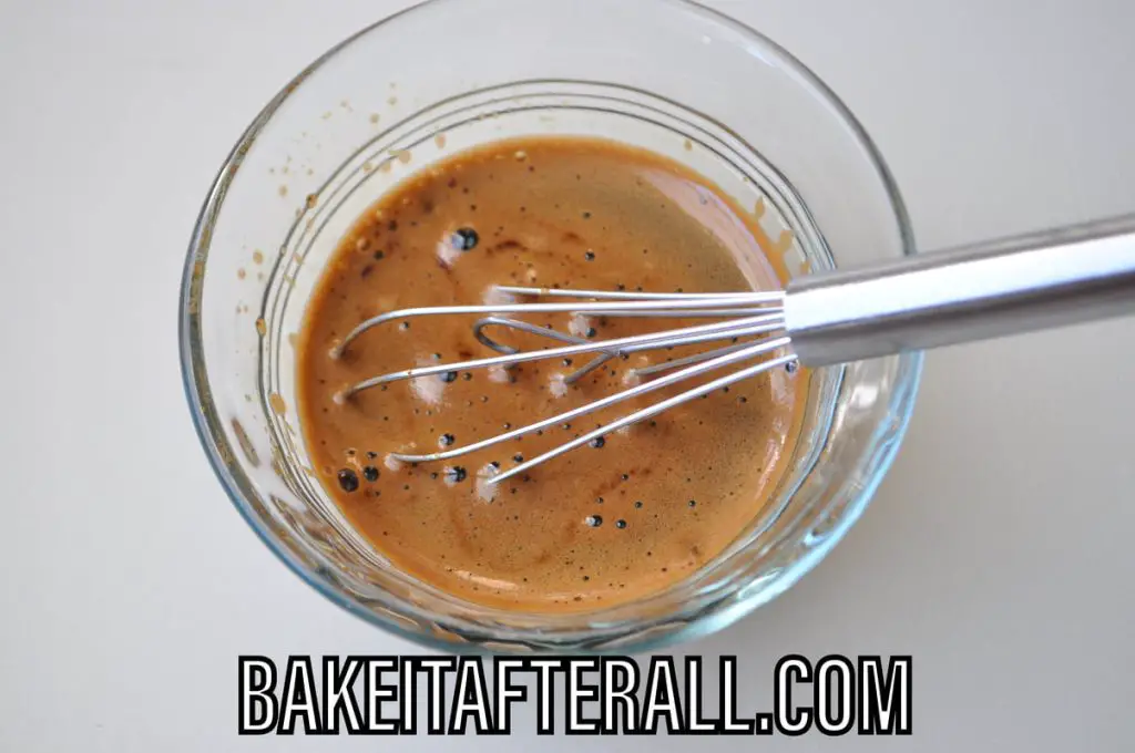 coffee mixed with espresso powder in a bowl with a whisk