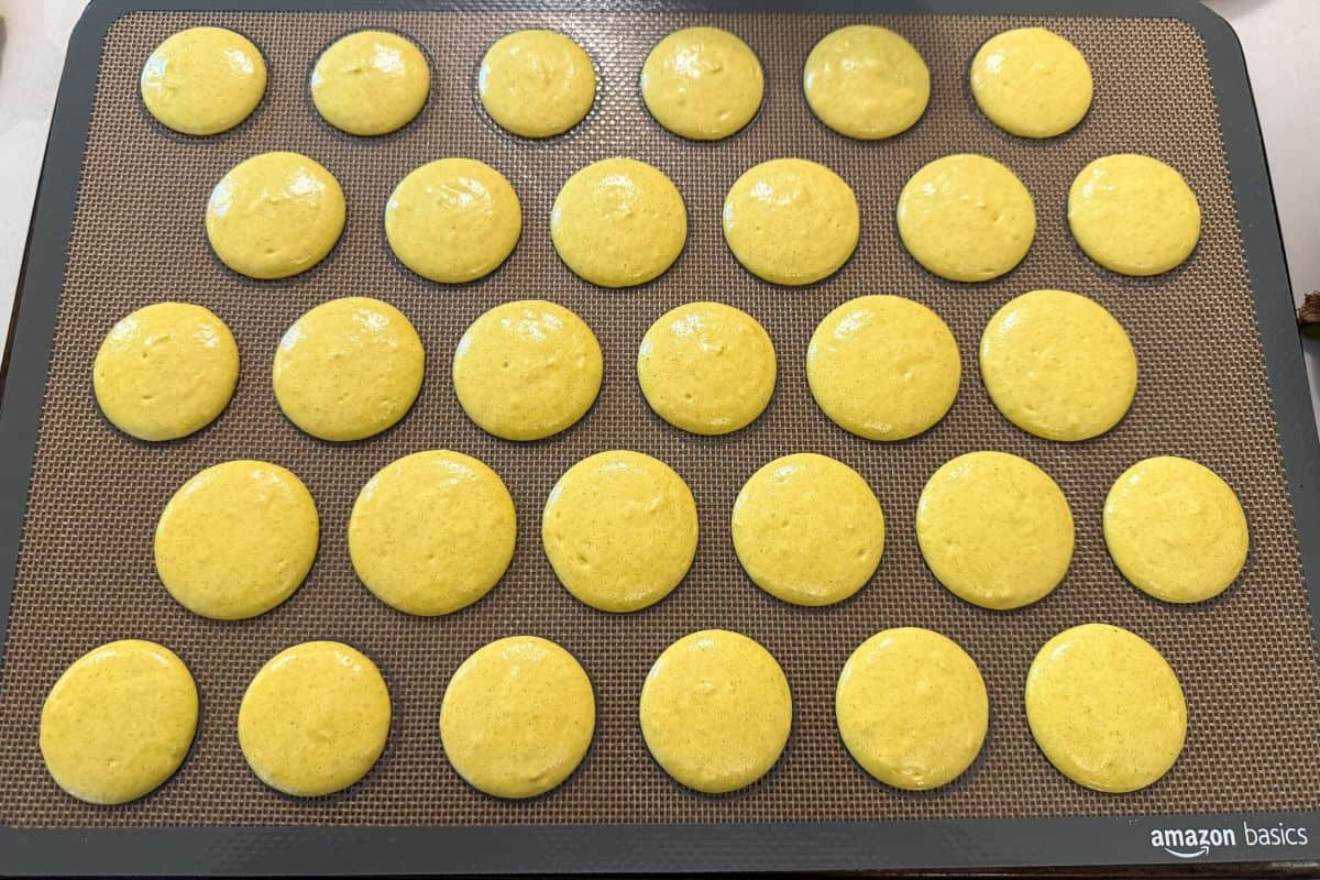 yellow Nut Free French Macaron shells piped on a macaron mat
