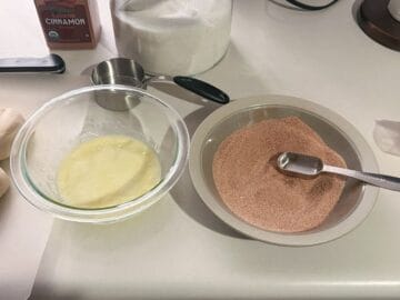 a bowl of melted butter next to a bowl of cinnamon sugar