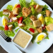 Fried Chicken Salad on a plate with a square dish of honey mustard dressing