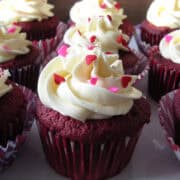 Red velvet cupcakes with Vanilla Swiss Meringue Buttercream on top sprinkled with heart sprinkles