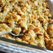 Thanksgiving Dressing in a casserole dish with a metal spoon in it
