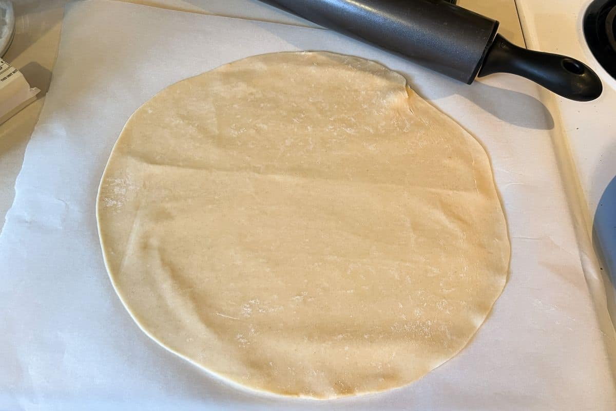 pie dough rolled out on a piece of parchment paper