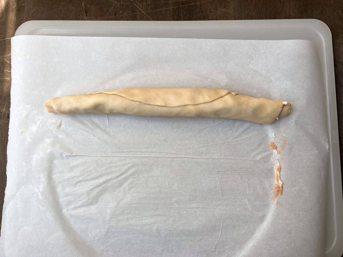 a rolled up pie dough with cinnamon sugar and butter inside