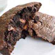a chocolate chocolate chip cookie broken open to show the chocolate chips inside