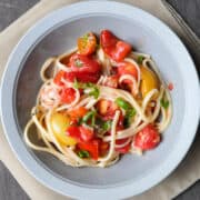 fresh tomato pasta in a bowl with a napkin underneath