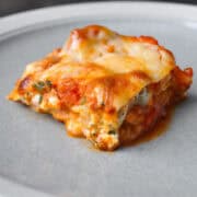 a slice of spinach lasagna on a stoneware plate