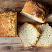 loaf of beer bread on a cutting board with slices of the bread stacked