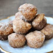 a platter with a stack of cinnamon sugar donut muffins