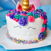 a Rainbow Unicorn Cake on a white cake stand