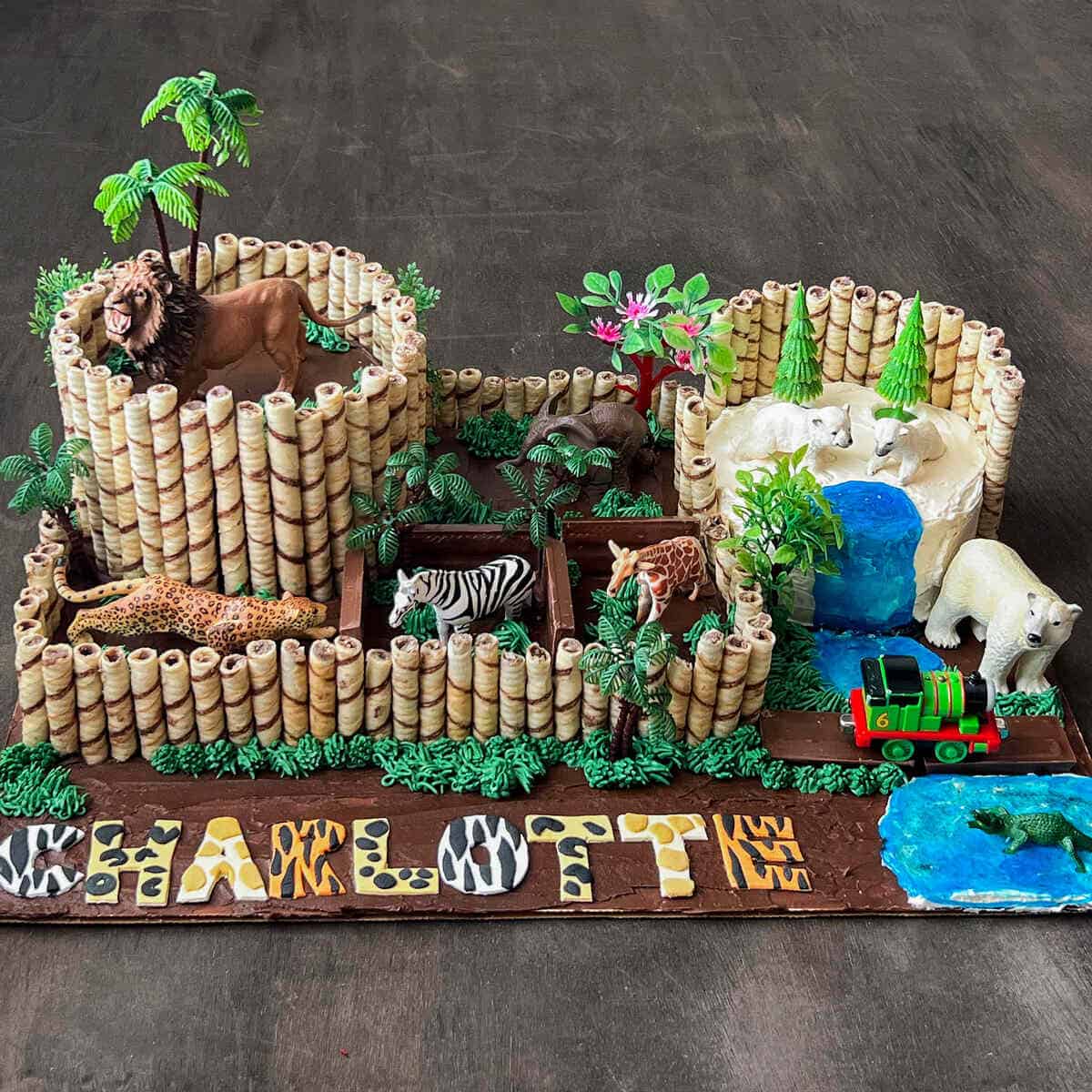 a zoo animal birthday cake with different animal exhibits