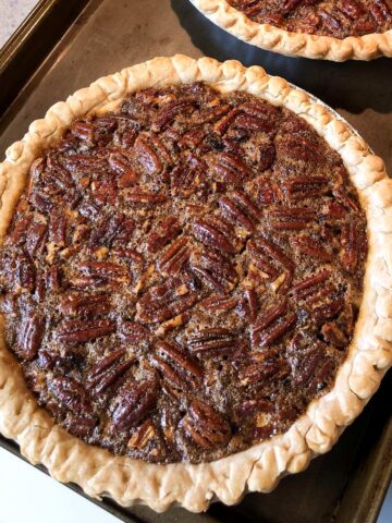 a pecan pie on a baking sheet on top of a stove