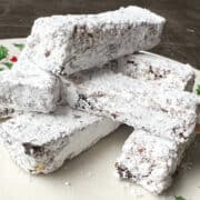 a plate with a pile of Nut Free Old Fashioned Date Bars stacked on top