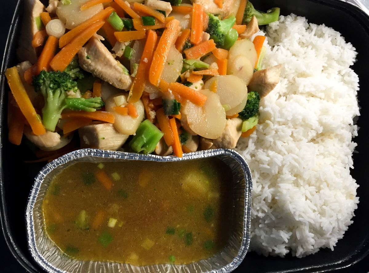Garlic Chicken Stir Fry packaged in foil pans with rice