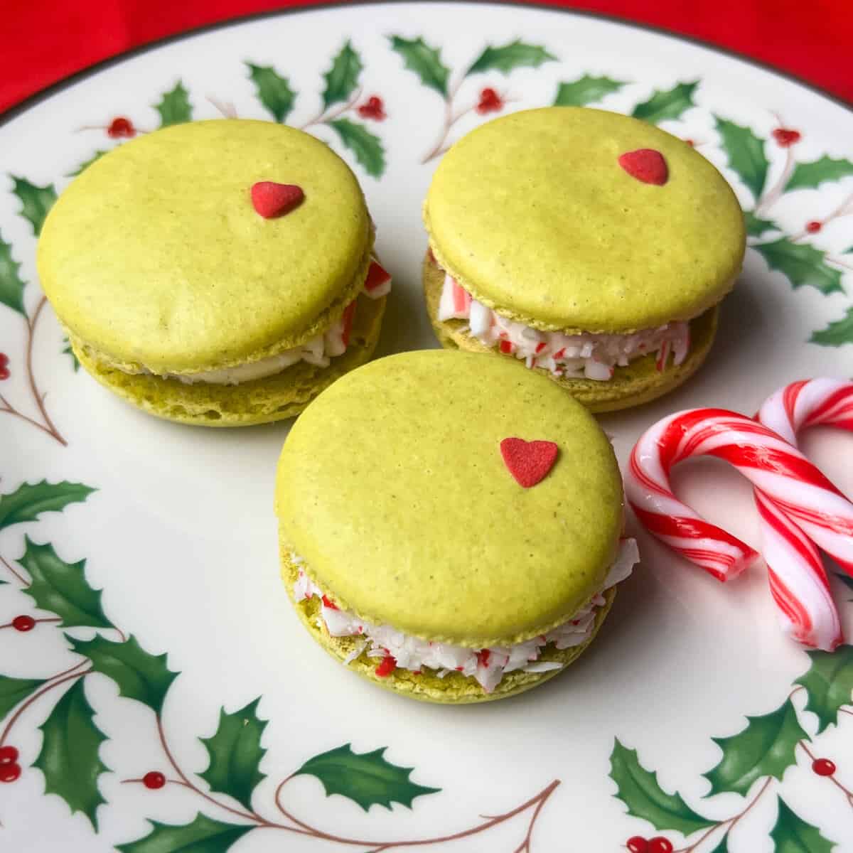 Nut Free Grinch Macarons on a plate with candy canes