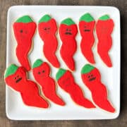 sugar cookies decorated like chili peppers with funny faces drawn on