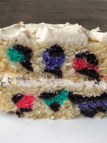 a cake slice cut to show the rainbow leopard print design inside