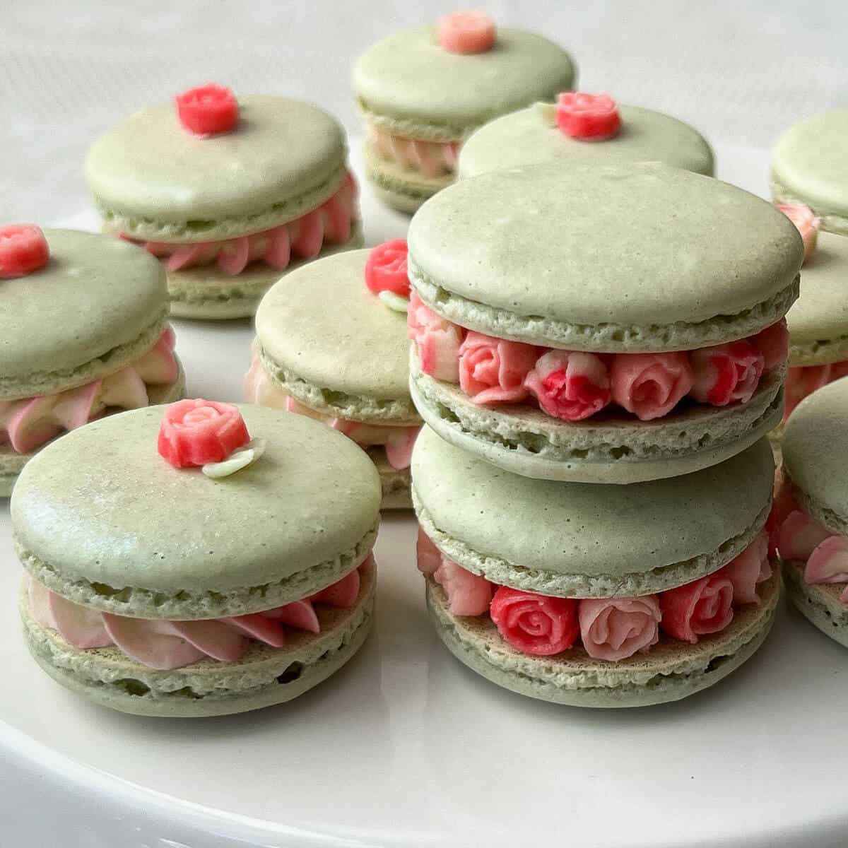 mini rose macarons on a white cake stand