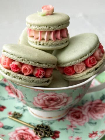 Mini Rose French Macarons in a tea cup on a saucer