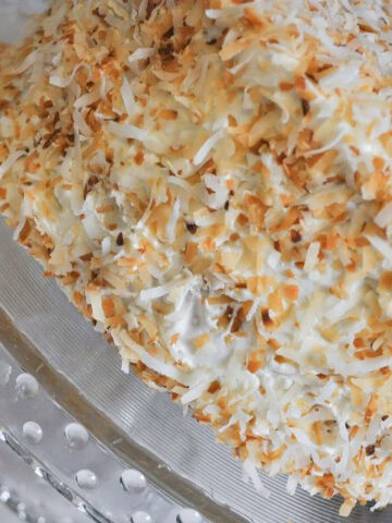 Toasted Coconut Cake on a glass cake stand