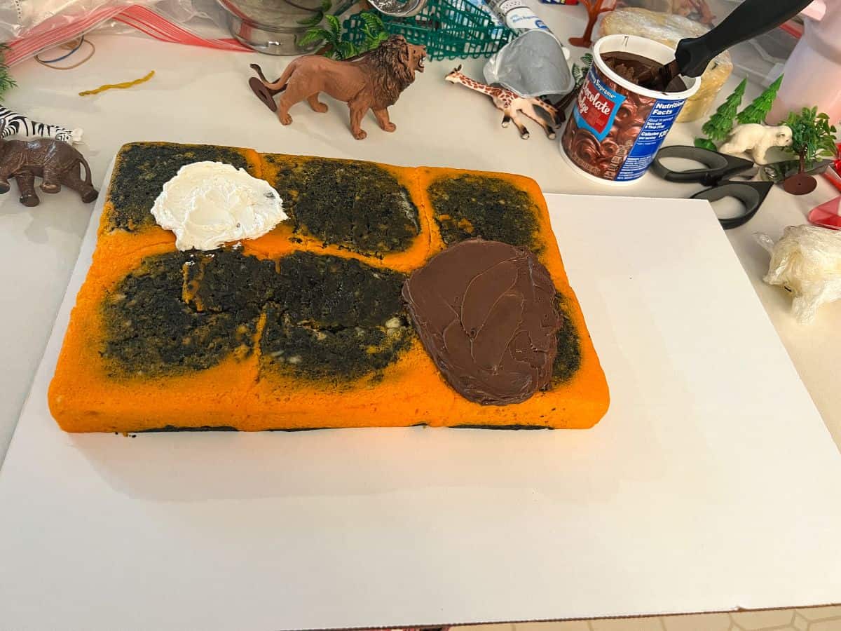 a rectangular cake on a white cake board with vanilla and chocolate frosting on the cake